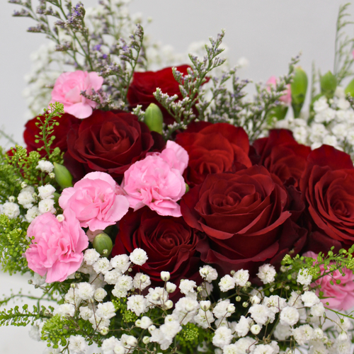 red roses and rose sprays with baby's breaths packed for a flower subscription box from a fresh flower wholesaler 